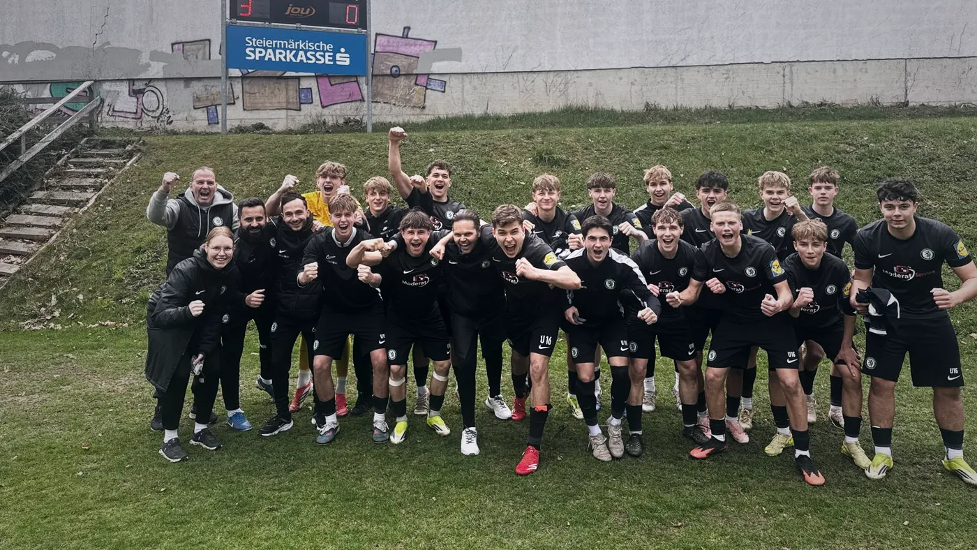 Nachwuchsmannschaft und Betreuer jubeln gemeinsam auf dem Fußballplatz